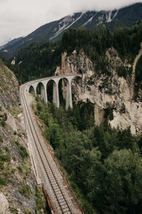 Arch bridge over mountains against sky