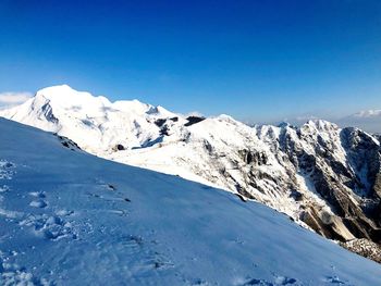 Scenic view of snowcapped mountains against clear blue sky