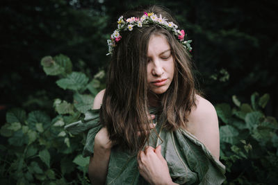 Beautiful young woman with crown in the forest
