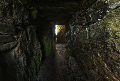 Footpath amidst rocks in tunnel