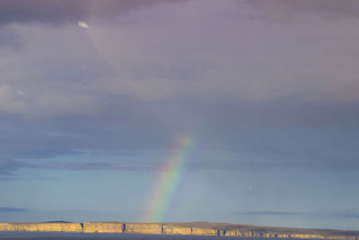 Rainbow over building against sky