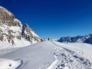 Full length of man standing on snow covered land against sky