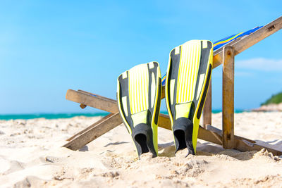 Deck chairs on beach against clear sky