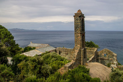 Panoramic view of old building by sea against sky