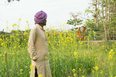 Rear view of people standing on field