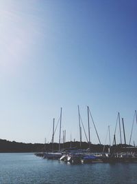 Boats moored in sea against clear sky