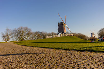 Traditional windmill on field against clear sky