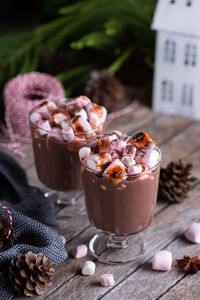 Traditional christmas drink, hot cocoa chocolate with roasted marshmallows on a festive table