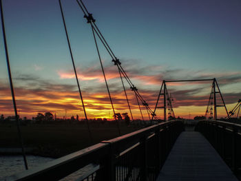 Suspension bridge against sky during sunset