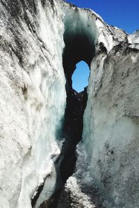 Water flowing through rocks against sky