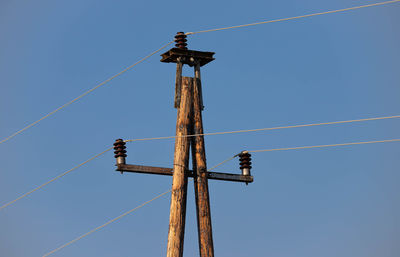 Low angle view of electricity pylon against sky