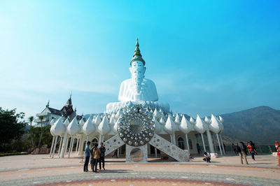 People in front of temple against clear sky