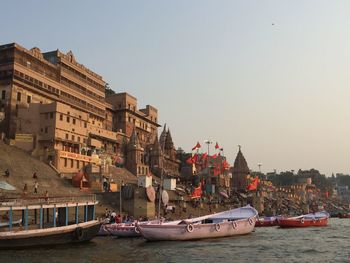 Boats in water against clear sky