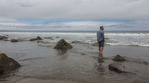 Man standing on beach against sky