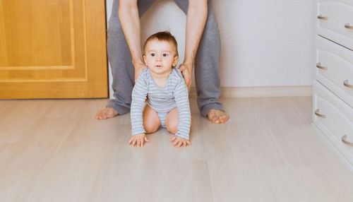 Full length of father and son on floor