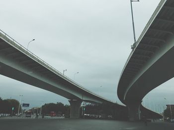 Bridge over road in city against sky