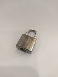 High angle view of padlocks on metal against white background