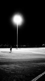 Man walking on illuminated street light at night