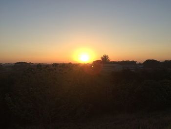 Scenic view of landscape against orange sky