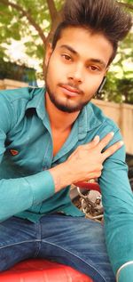 Portrait of young man sitting outdoors