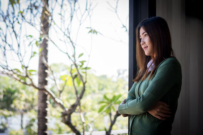 Side view of a young woman standing outdoors