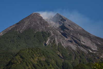 Low angle view of volcanic mountain against sky