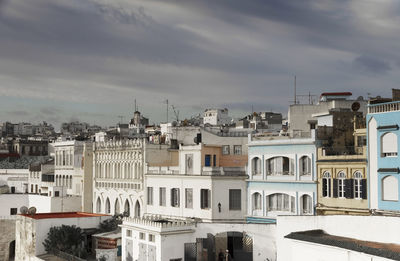 Buildings in city against cloudy sky