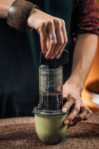 Midsection of woman making coffee in cafe