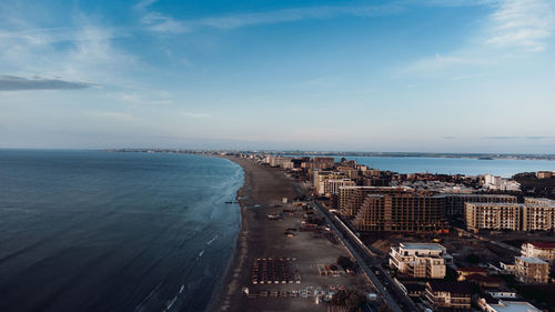 High angle view of city by sea against sky