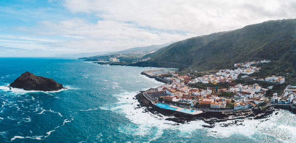 High angle view of sea and mountains against sky