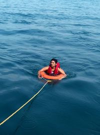 High angle view of woman with lifebelt in sea