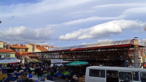 People at market against sky in city