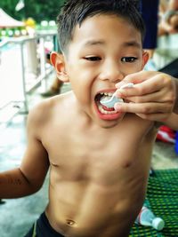 Close-up of shirtless boy holding ice cream