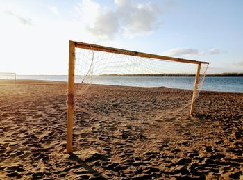 Soccer field by sea against sky