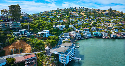 High angle view of townscape by sea against sky