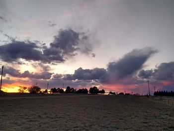 Scenic view of dramatic sky over land during sunset