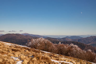 Scenic view of mountains against clear blue sky