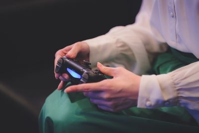 Midsection of woman holding video game controller