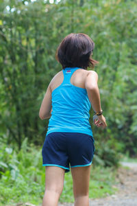 Rear view of boy against trees