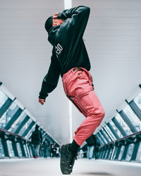 Low section of man skateboarding on railing against wall