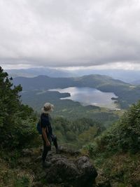 Man looking at mountains against sky