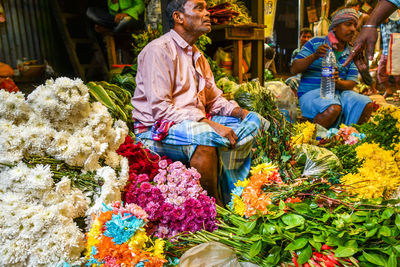 People in traditional clothing for sale at market stall