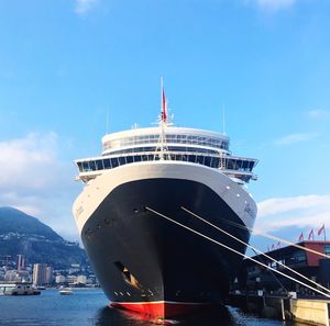 Ship moored at harbor against sky