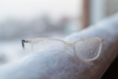 Close-up of eyeglasses on snow