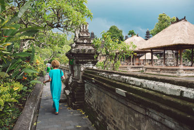 Rear view of woman walking at temple