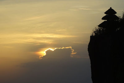 Silhouette rocks against sky during sunset