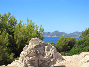 Scenic view of rocks against clear blue sky