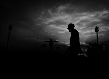 Silhouette man standing against sky during sunset