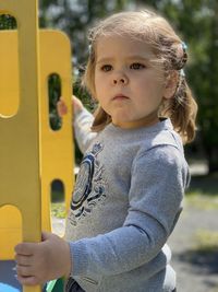 Cute girl looking away while standing outdoors