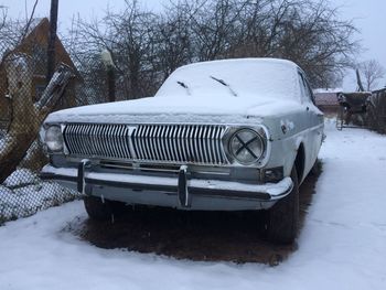 Snow covered car on field